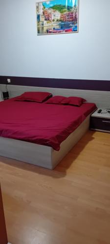 a bedroom with a bed with a red comforter at Stefy Beach Apartment in Kavarna