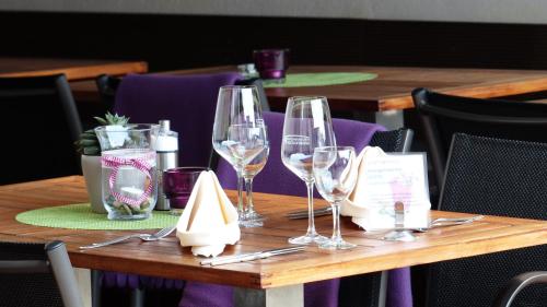 a wooden table with wine glasses and napkins on it at Hotel Rosenbusch in Großheubach