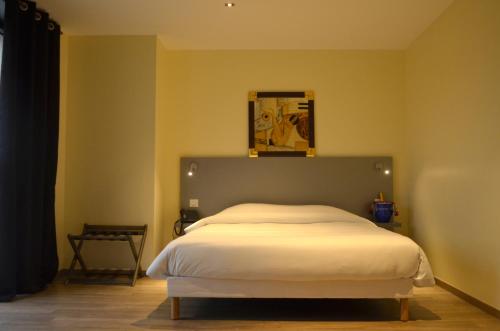 a bedroom with a large bed in a room at Le Grand Hotel in Maubeuge