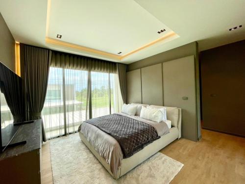 Ban Mae ChongにあるVanalux Garden Villa Chiangmaiのベッドと大きな窓のある寝室