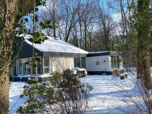 a blue and white building in the snow at Holiday Home in Haaksbergen by Lake in Haaksbergen