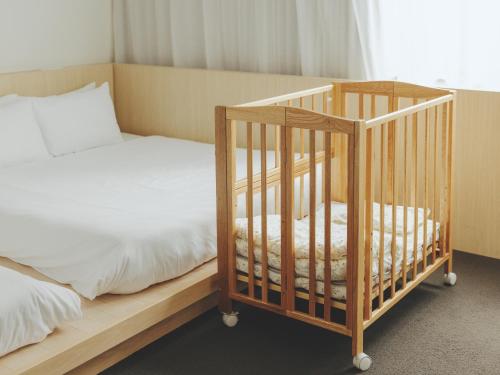 a bedroom with a bed and a wooden crib at SOKI Kanazawa in Kanazawa