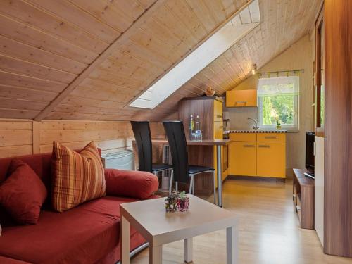 a living room with a red couch and a table at Apartment near Rennsteig in Goldisthal