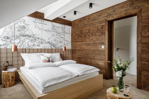 a bedroom with a bed with a wooden wall at udanypobyt Apartamenty Dranica in Zakopane