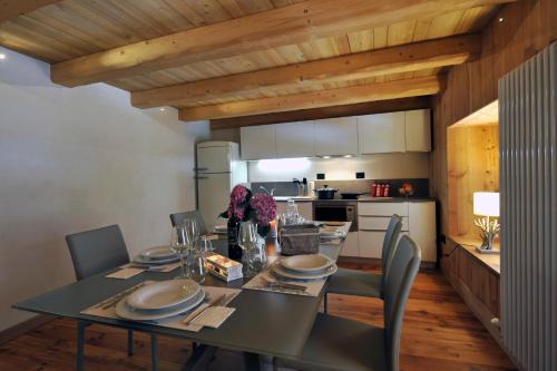 a dining room with a table and chairs and a kitchen at Historic Residenze Loo Bach in Gressoney-Saint-Jean