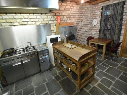 a kitchen with a stove and a table in it at Lodge Maasduinen near National Park in Wellerlooi