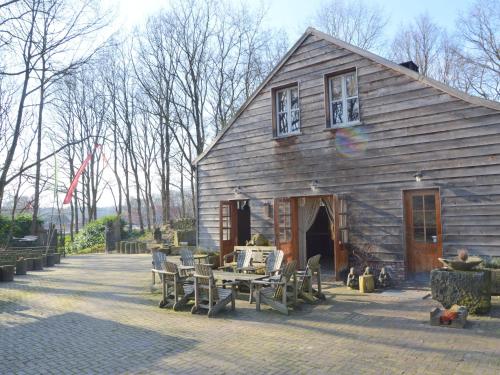 a barn with a table and chairs in front of it at Lodge Maasduinen near National Park in Wellerlooi