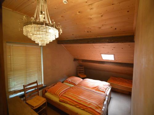 a bedroom with a bed and a chandelier at Lodge Maasduinen near National Park in Wellerlooi