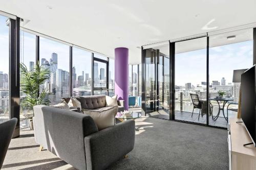 a living room with a couch and a view of the city at Docklands Harbour View 3BR with Free Parking in Melbourne