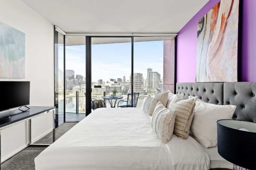 a bedroom with a large white bed with a view at Docklands Harbour View 3BR with Free Parking in Melbourne