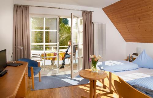 Zimmer mit einem Bett und einem Tisch mit einer Blumenvase in der Unterkunft Gasthof Schweizerhof in Villingen-Schwenningen