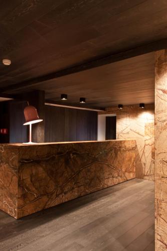 a lobby with a stone counter and a chair at Alexander Charme Hotel in Livigno