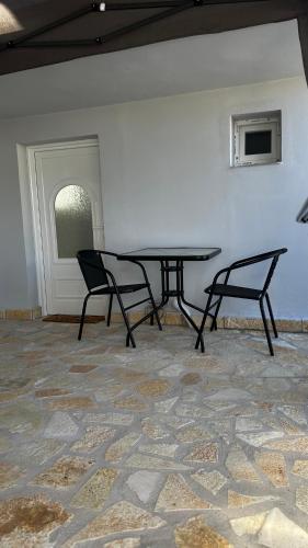 a table and two chairs in a room at Steven Eleonas apartments in Eleonas
