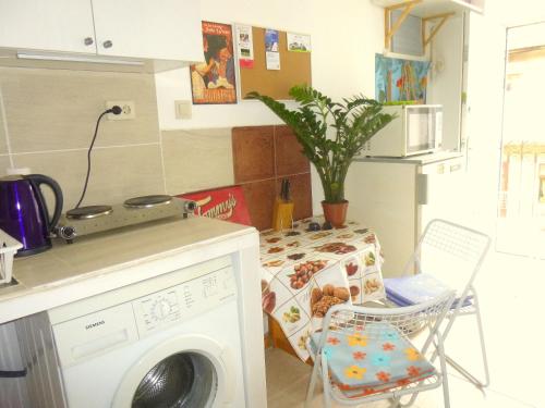 a kitchen with a washing machine and a table at BZE Apartment in Budapest