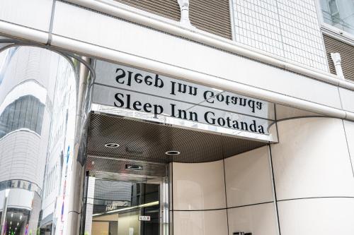a street sign on the side of a building at Sleep Inn Gotanda in Tokyo