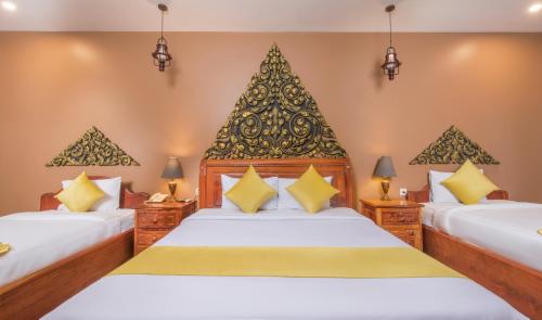 ein Hotelzimmer mit zwei Betten und zwei Lampen in der Unterkunft Indra Porak Residence Hotel in Siem Reap