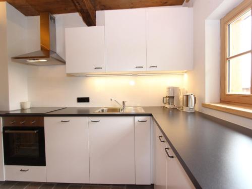 a kitchen with white cabinets and a sink at Chalet in Tyrol on St Johanns Ski Slope in Apfeldorf