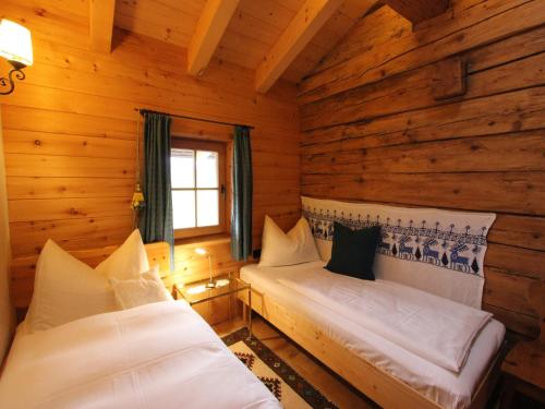 a bedroom with two beds in a log cabin at Chalet in Tyrol on St Johanns Ski Slope in Apfeldorf