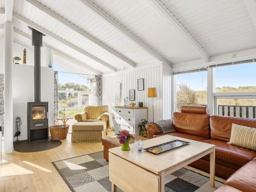 a living room with a couch and a fireplace at 4 star holiday home in Hjørring in Kærsgård Strand