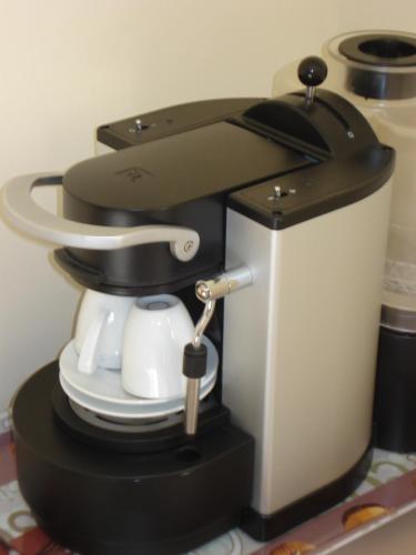 a black and white coffee maker on a table at La Tour Des Lys in Maubeuge