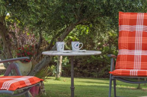 two coffee cups on a table next to a chair at Luxury Villa Karteros in Karteros