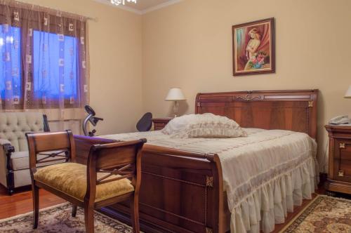 a bedroom with a bed and two chairs and a window at Luxury Villa Karteros in Karteros