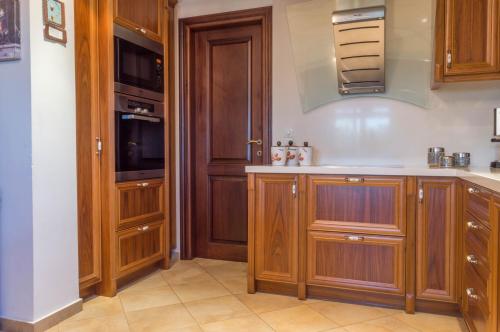 a kitchen with wooden cabinets and a stove at Luxury Villa Karteros in Karteros