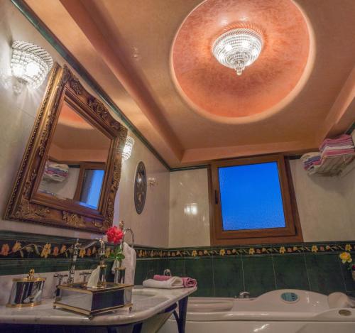 Luxury Villa Karteros في كارتيروس: حمام مع حوض ومغسلة ومرآة
