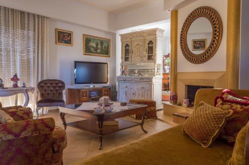 a living room with a couch and a table and a tv at Luxury Villa Karteros in Karteros