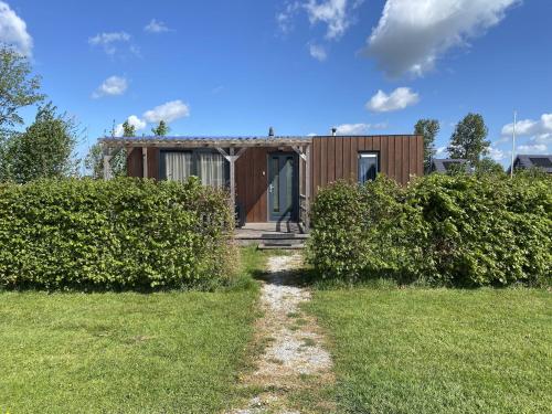a wooden house with a pathway leading to it at Chalet in Friesland near Alde Feanen Park in De Veenhoop