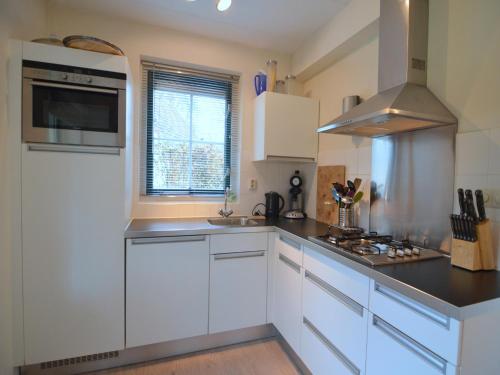 a kitchen with white cabinets and a stove at Holiday Home in Heeten near Forest in Heeten