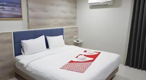 a large white bed with two dishes on it at Sattahip 9 Boutique Hotel in Pattaya Central