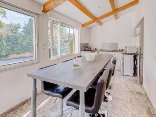 Una cocina con una gran mesa y sillas de madera. en Holiday Home La Seyne near Beaches, en La Seyne-sur-Mer