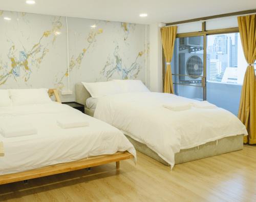 a bedroom with two beds and a window at Big unit for 8 people, city center Silom in Bangkok