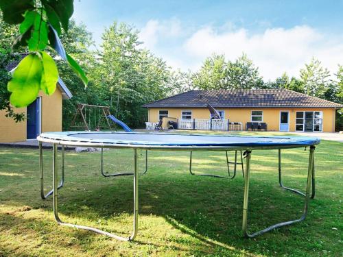 a trampoline in a yard in front of a house at 12 person holiday home in Hojslev-By Traum in Bøstrup