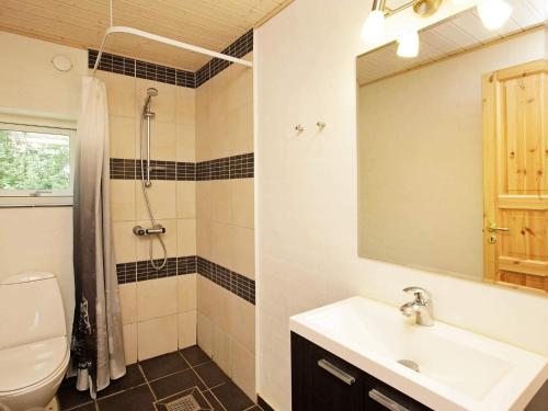 a bathroom with a sink and a toilet and a mirror at 12 person holiday home in Hojslev-By Traum in Bøstrup