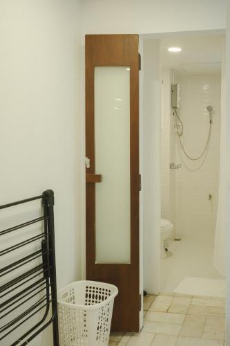 a bathroom with a toilet and a door with a mirror at Big unit for 8 people, city center Silom in Bangkok