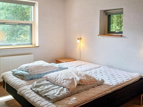 two unmade beds in a room with two windows at 12 person holiday home in Hojslev-By Traum in Bøstrup