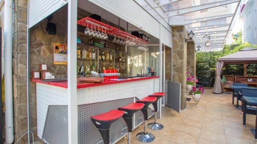 een bar met rode aanrechtbladen en krukken bij Villa Valentina in Alushta