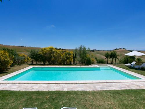 a swimming pool in the middle of a yard at Tuscan Hilltop Farm Stay in Castelnuovo Berardenga