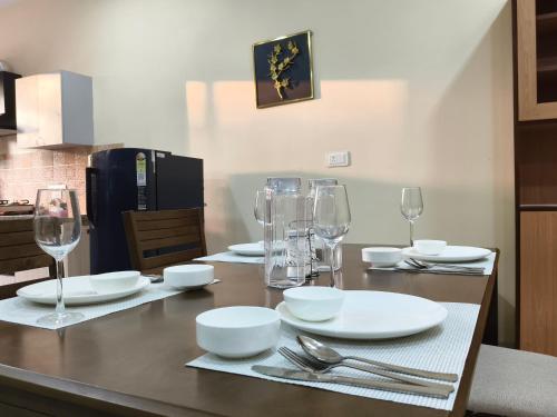 a table with plates and glasses and silverware on it at Galaxy Villa Modern 1BHK Apartment in Kālwāra