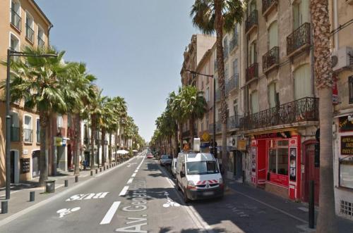 a street with a car parked on the side of the road at Hotel du Berry in Perpignan