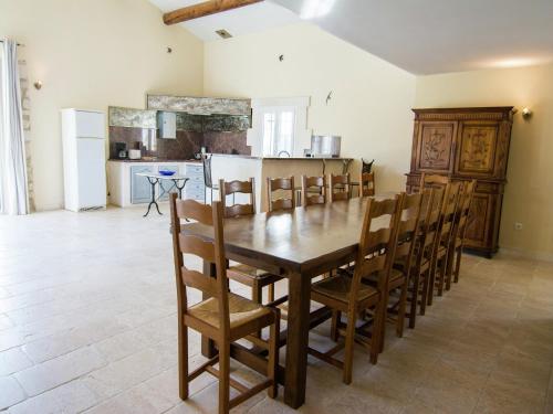 a kitchen and dining room with a wooden table and chairs at Vineyard Villa in Montfrin in Montfrin