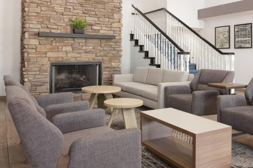 a living room with chairs and a fireplace at Garner Hotel Phoenix Northwest - Surprise by IHG in Surprise