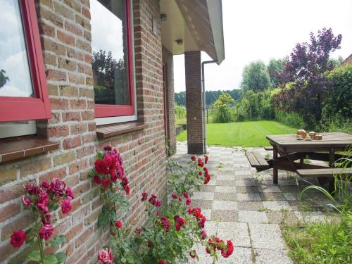 a brick building with a picnic table and flowers at Holiday Home near Bruges and Cadzand in Eede