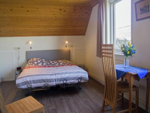 a bedroom with a bed and a table and a window at Holiday Home near Bruges and Cadzand in Eede