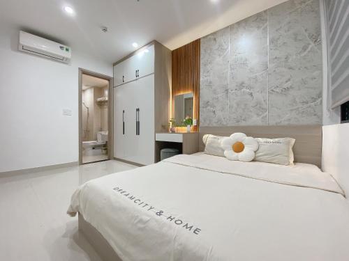 - une chambre dotée d'un grand lit blanc avec un ours en peluche dans l'établissement Hue Charm Apartment -Nera Garden, à Thôn Văn Dương