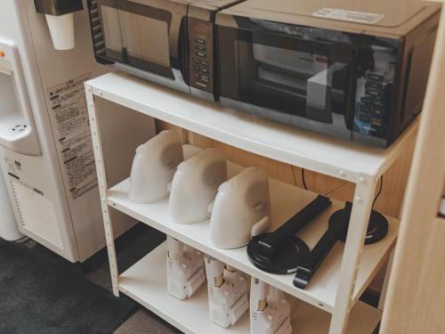 a microwave on top of a white shelf at SOKI Kanazawa in Kanazawa