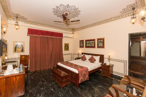 
a bedroom with a large bed and a large window at Umaid Mahal - A Heritage Style Boutique Hotel in Jaipur
