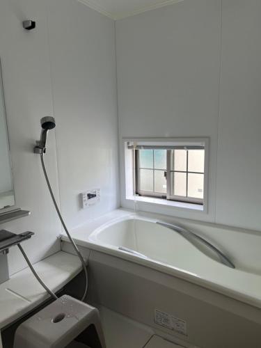 a bath tub in a bathroom with a window at House tomari木-山梨 in Yamanashi